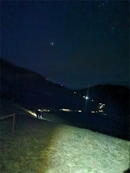 Line of aviation photographers climbing AXALP 2023 at night
