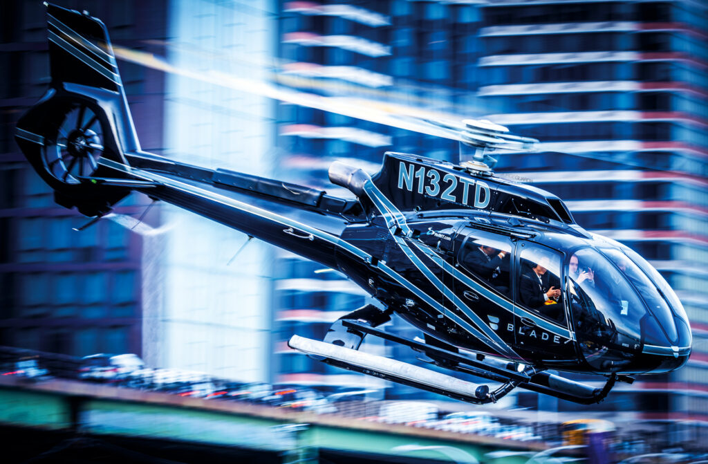 Airbus Helicopters EC120 Colibri taking off between skyscrapers at Manhattan, NY
