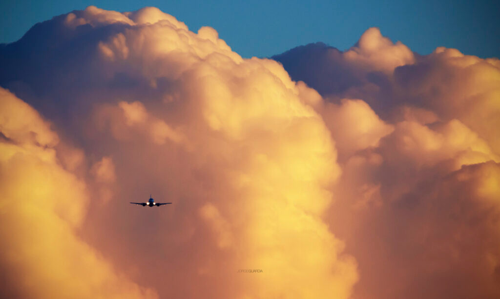 Boeing B737 at sunset with cumulonimbus clouds in the background at magic light